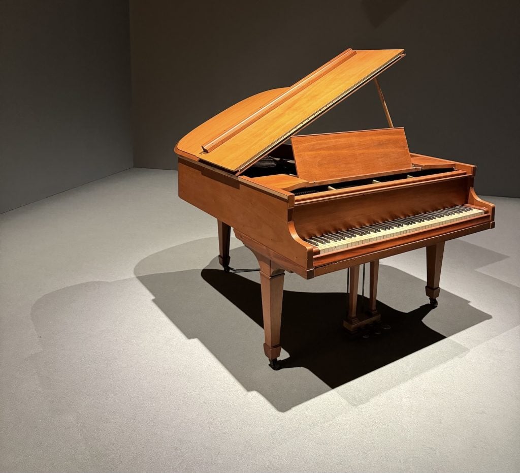 A brown piano in a darkened room