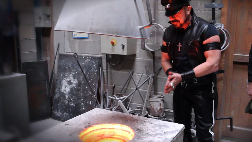 peter marino clad in leather is at a burning forge