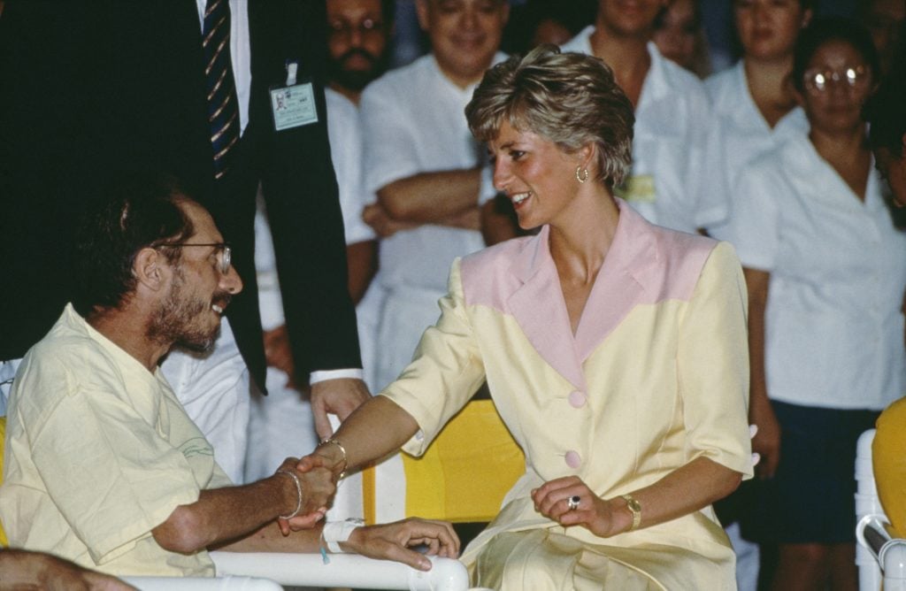 Princess Diana sits with an AIDS patient