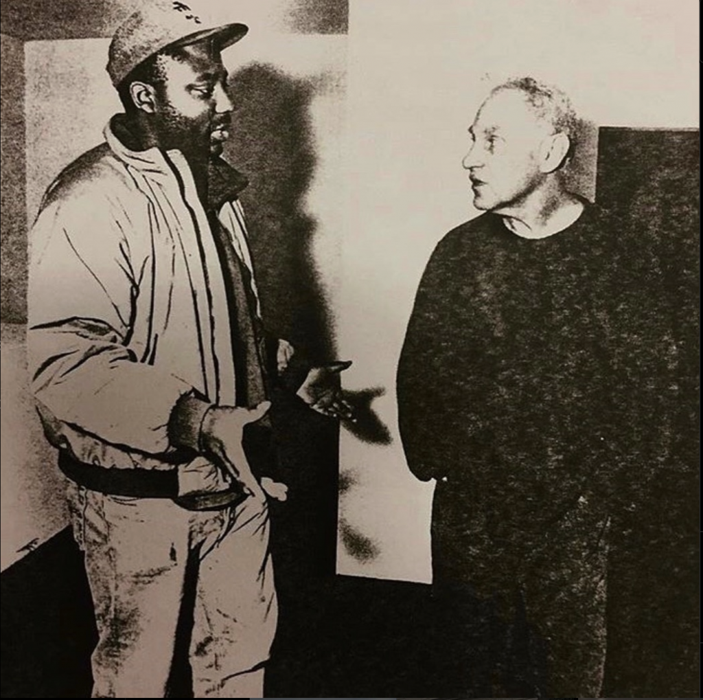 Artist Rico Gatson stands speaking with artist Richard Serra.
