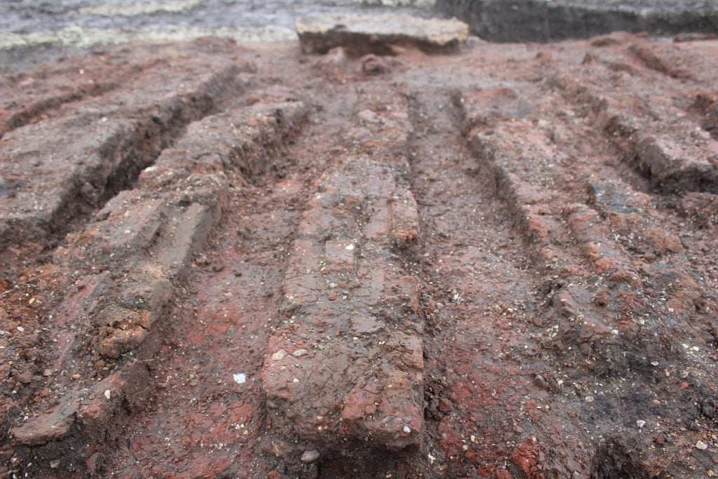 A line of ancient Roman bricks, part of an archaeological excavation.