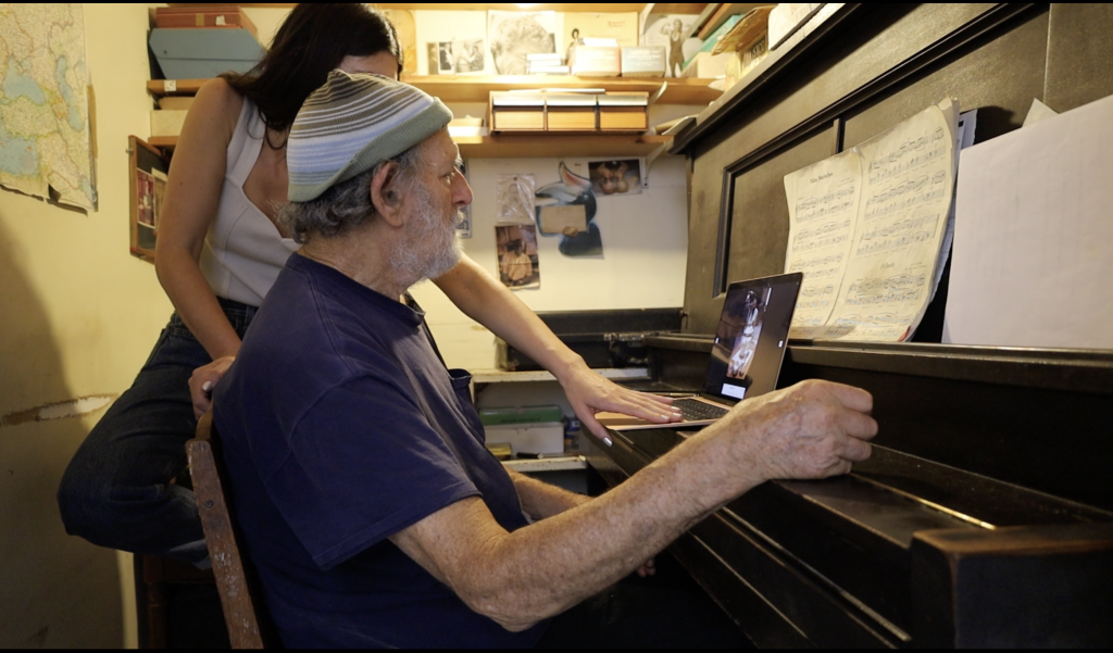 a young woman, Sachi Moskowtiz, at the piano with an elderly man, her grandfather Michael Frimkess