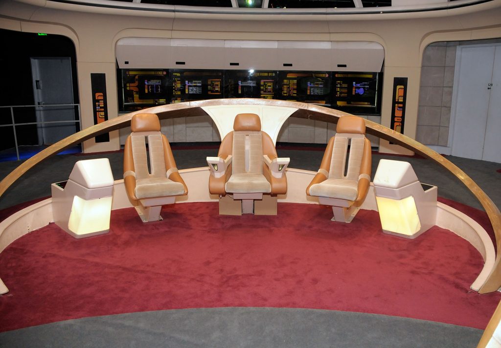 A spaceship set from the Star Trek TV series, featuring three chairs arranged in a semicircle.