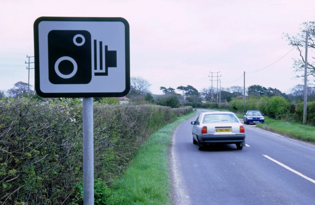 the road sign depicts a sideways view of an old bellows camera