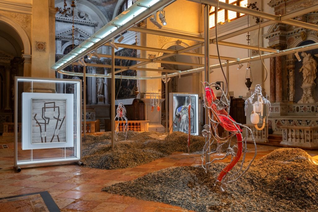 installation view of modern metal sculptures and hanging glass in a historic venetian church