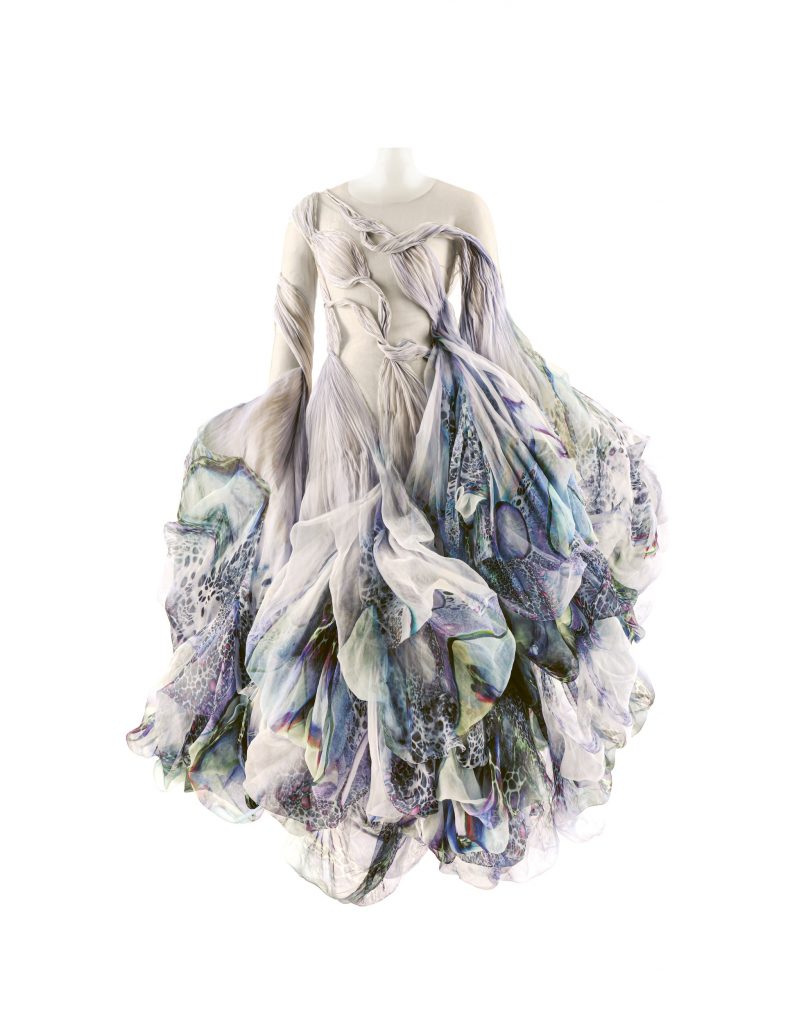 A dress designed by Iris van Herpen featuring loose billowy sections that have been painted with blue and purple patterns