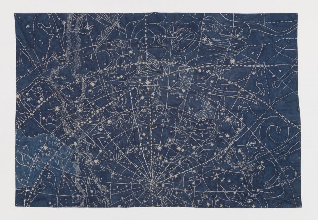 denim textile stitched with golden thread depicting the cosmos