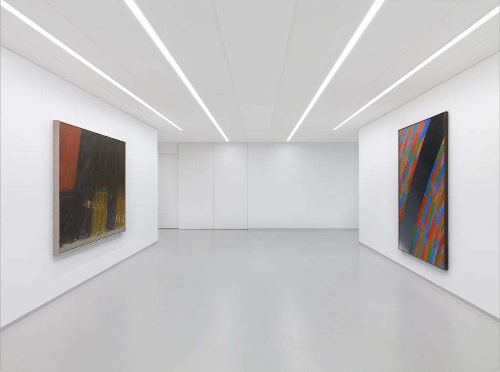 Two abstract paintings on opposite walls of a white cube gallery space.