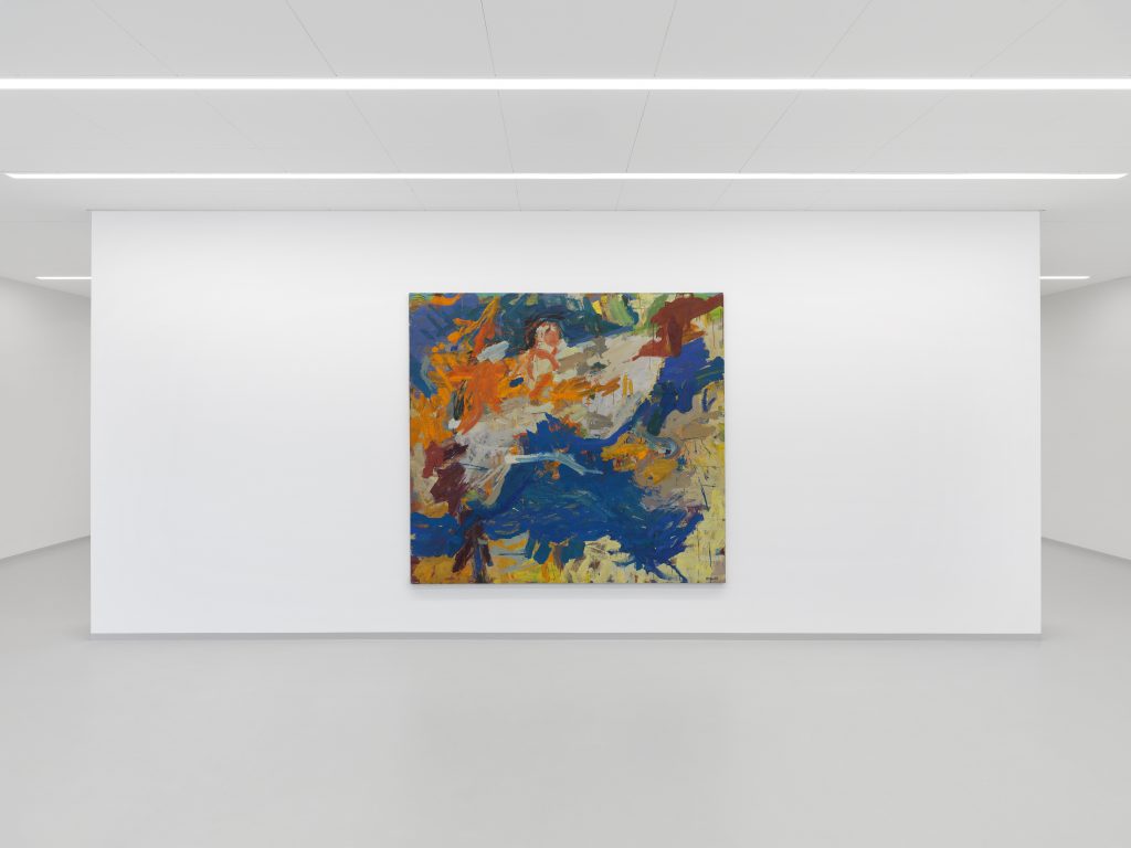 An abstract paintings on the wall of a white cube gallery space with three rows of lights along the ceiling.