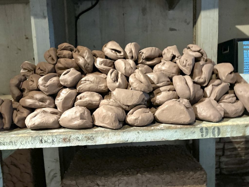 A shelf full of a pile of soft clay forms