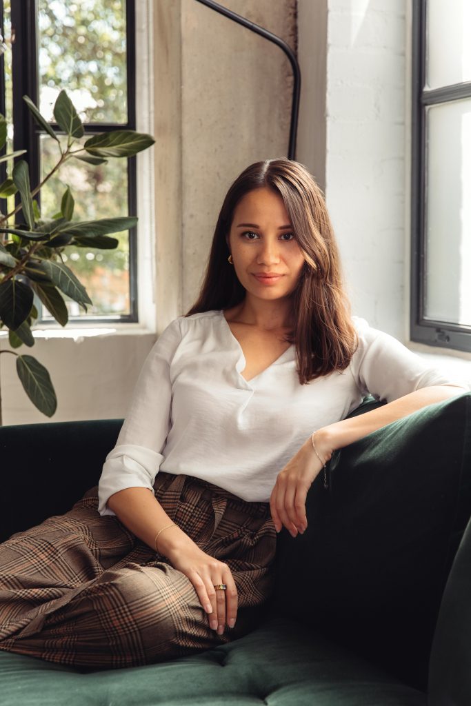 This image shows a woman in a white shirt sitting on a couch.