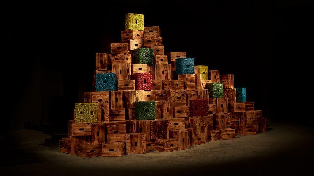 a large mountain of designer crates by Bottega Veneta, including some wrapped in colorful braided leather