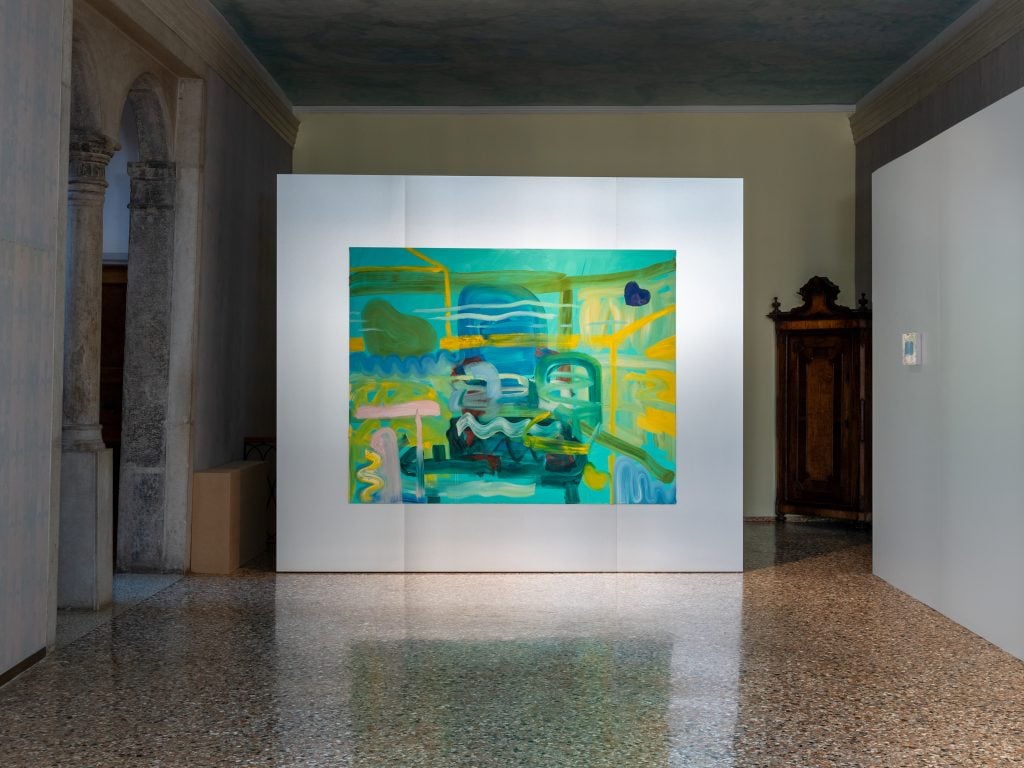 A room inside of a historic Venetian home with an abstract painting in blues and greens installed on a steel temporary wall.