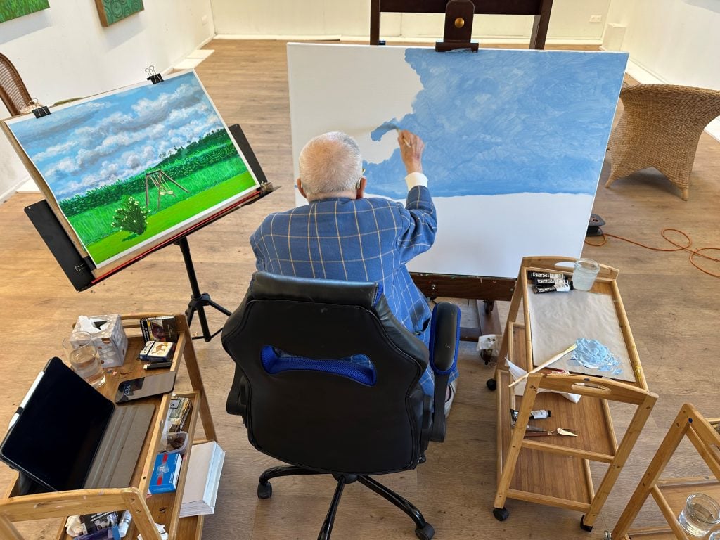 David Hockney painting in his studio