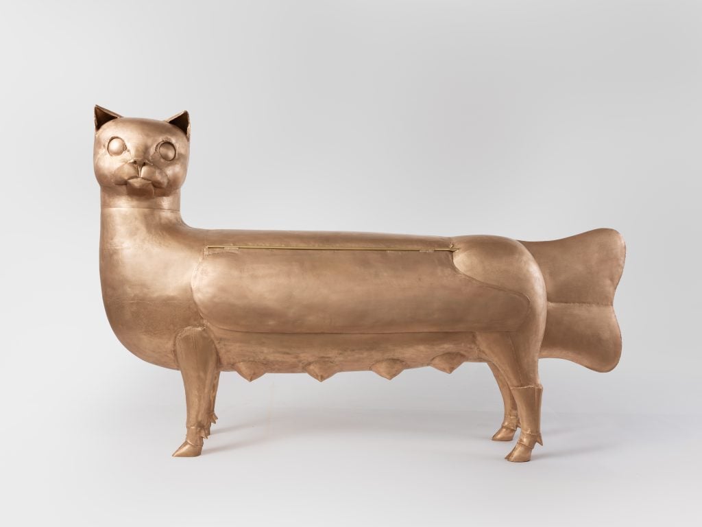 a large sculpture of a sphinx-like cat is on a white background 
