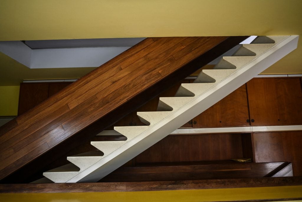 a modern staircase emerges from the ceiling 