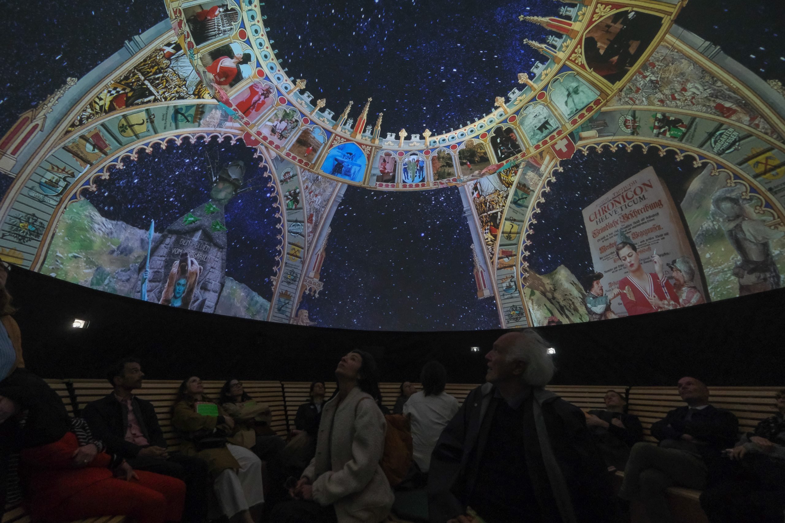 people look up at a celestial style installation in the swiss pavilion in the giardini