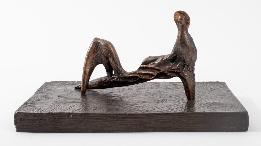 A figurative abstract sculpture in bronze of a reclining figure on a bronze base.