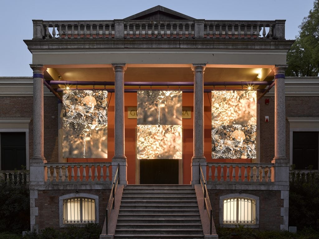 The facade of the British pavilion lit up with video work by John Akomfrah.