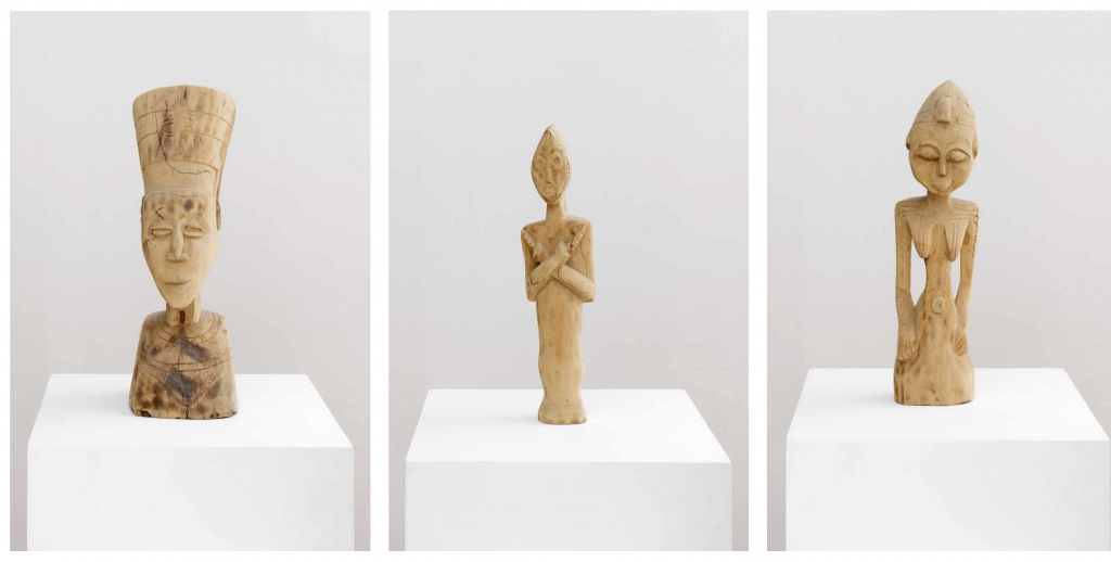 a triptych of three photographs of carved wooden statues on a white podium against a grey background