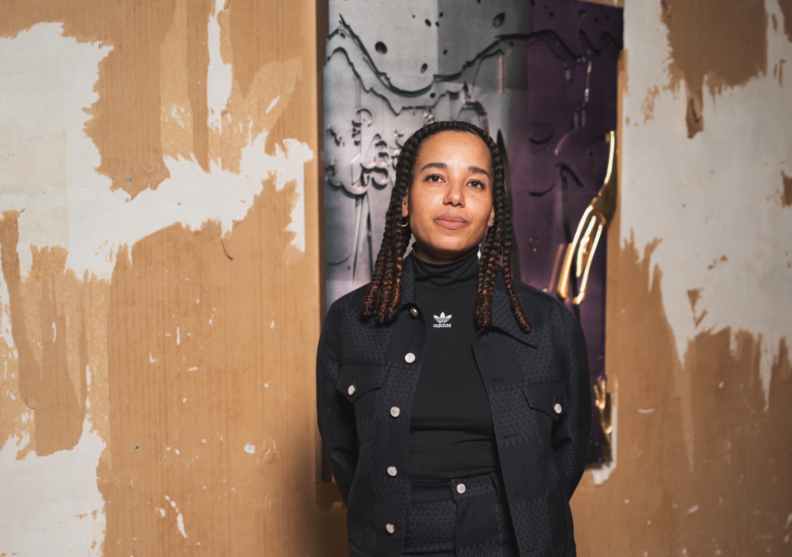 woman stands in front of an artwork