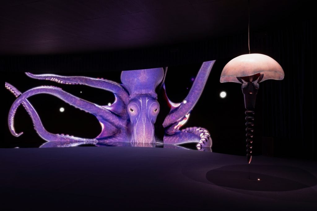 a large purple octopus occupies a long curved LED screen