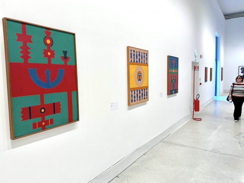 Three geometric abstract paintings hung in a gallery 
