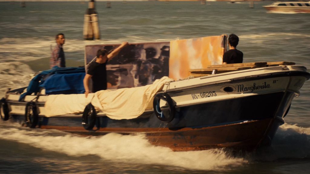 A film still showing a barge loading with canvases speeding through water