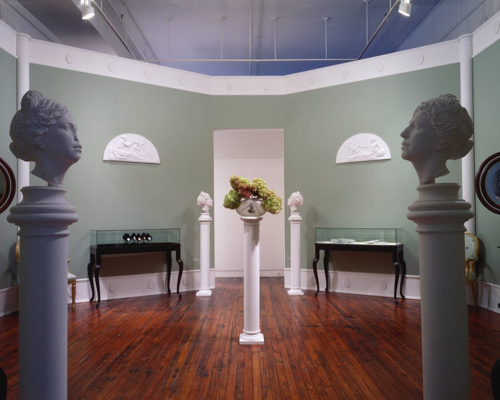 An art display in the form of an elegant room with busts of the artist in the foreground
