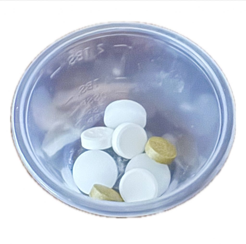 A color photo shows a container filled with pills