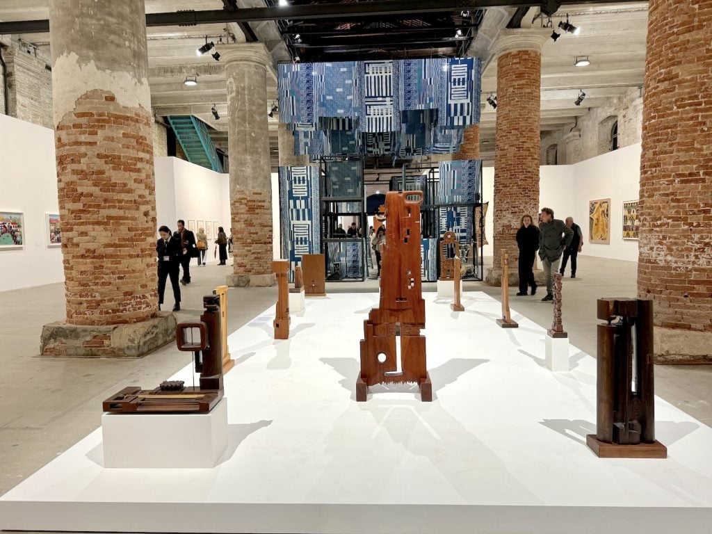 Several abstract wooden sculptures on a low plinth