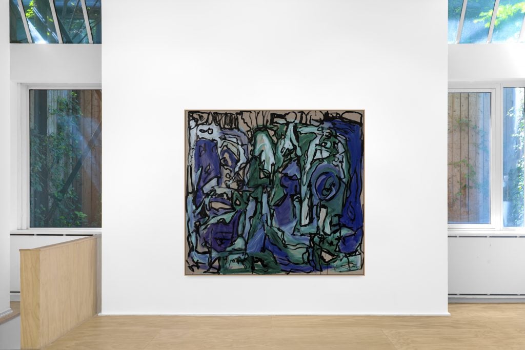 a gallery room with a large blue and green abstract canvas