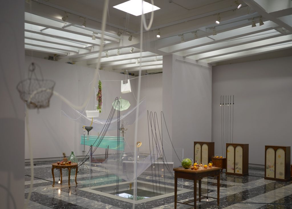 a large room with a strange and precarious assemblage of found items suspended and placed 