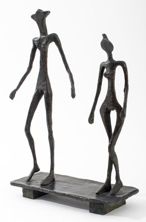 A bronze figurative abstract sculpture of two people walking side by side.