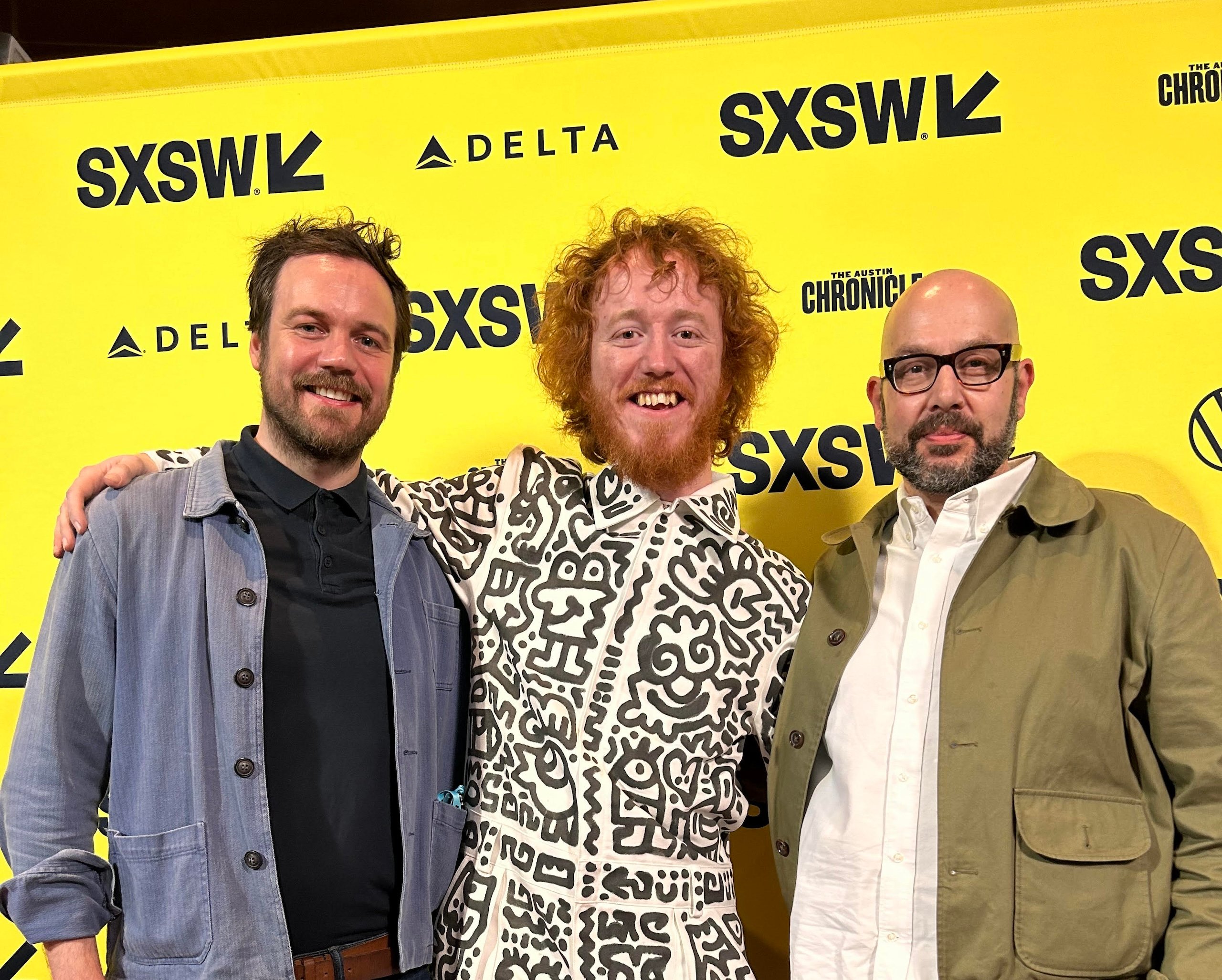 Three men in front of a banner for the South by Southwest festival