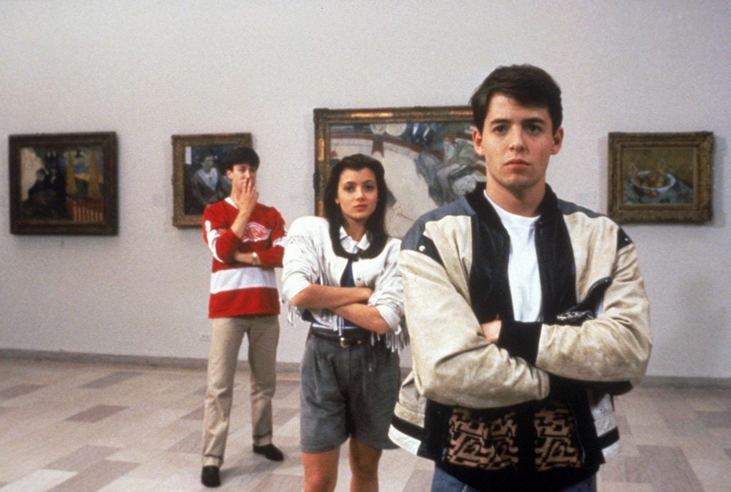 A woman and two men standing with arms crossed in a gallery hung with paintings, in a still from Ferris Bueller's Day Off.