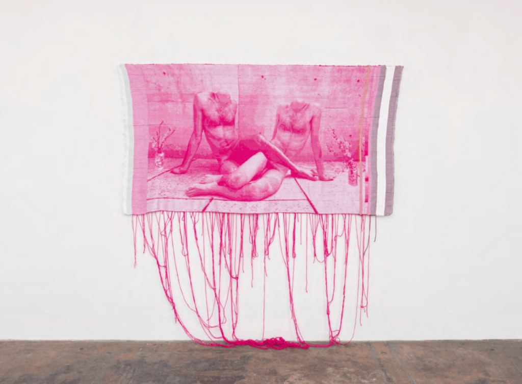 a hot pink tapestry shows two headless busts intertwined