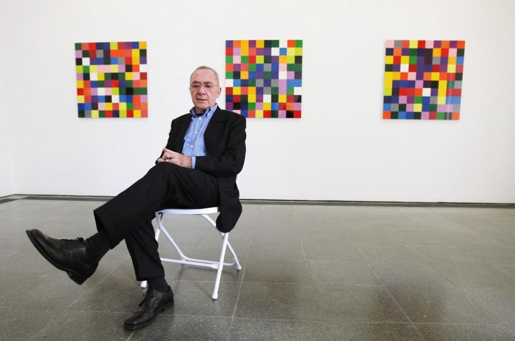 portrait of gerhard richter sitting on a chair infront of his new work titled 4900 colours