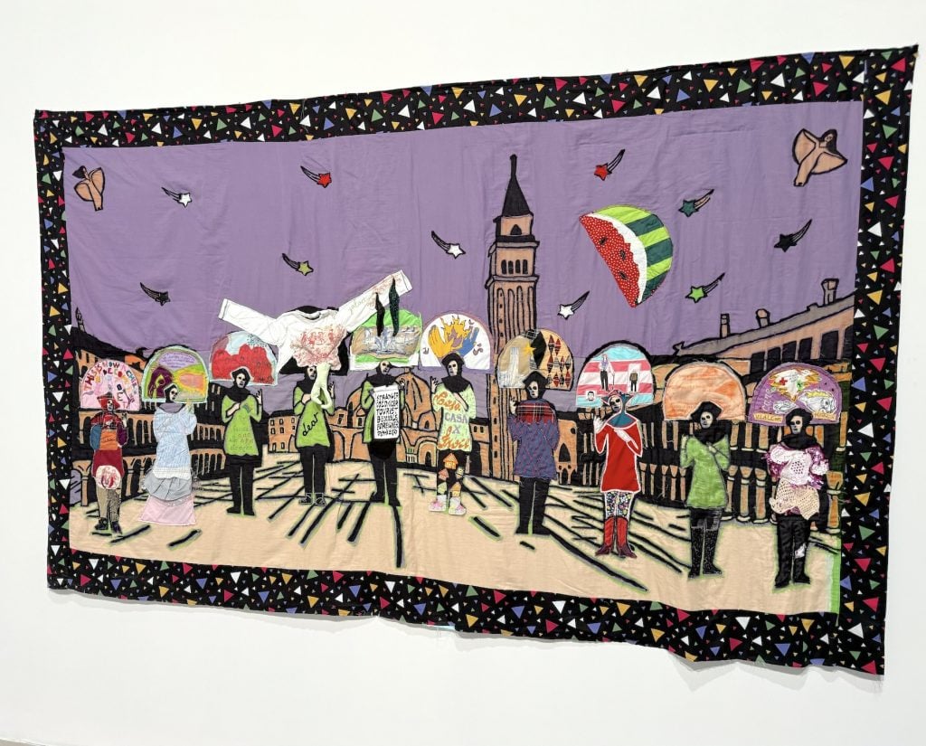 A textile work featuring a row of people in a plaza with a flying watermelon above them