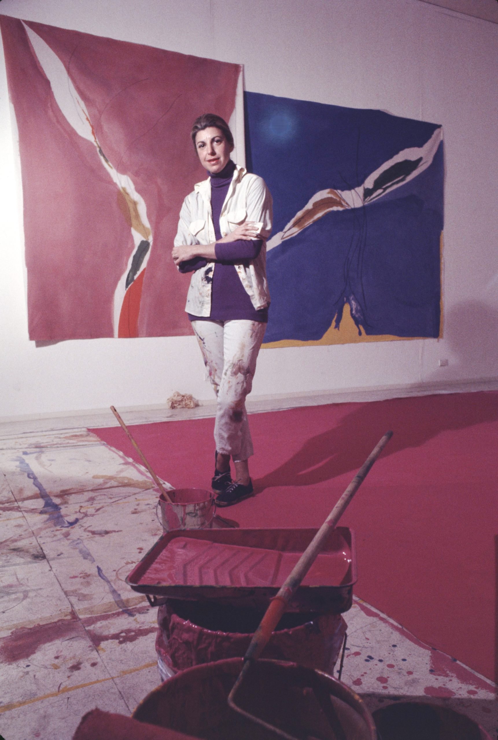 Helen Frankenthaler in her New York City studio, 1971. Two large canvases hanging behind her on the wall, with a tray of red paint in the forground.