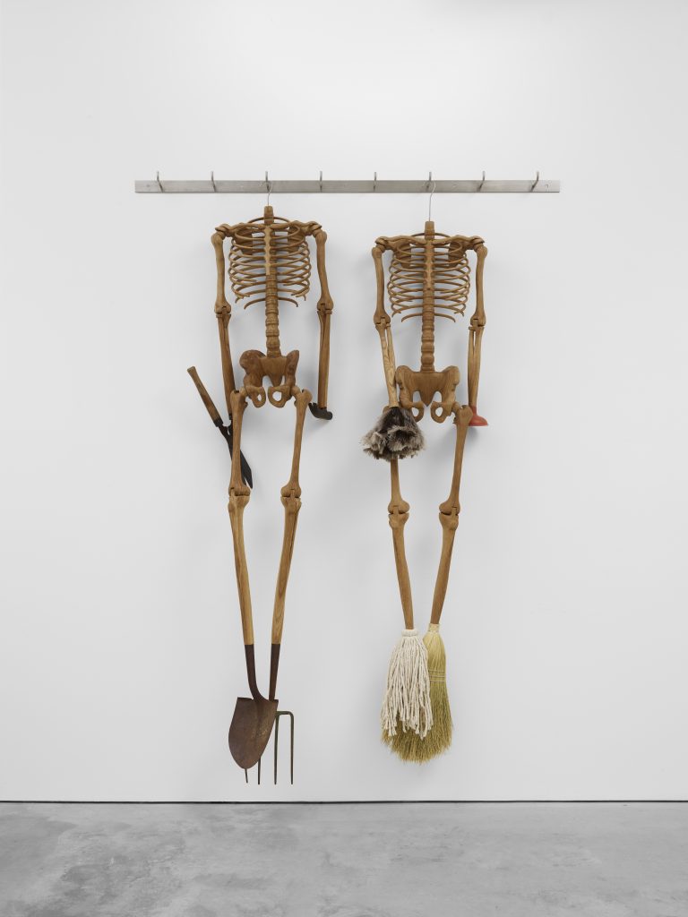 From the shows to see list, two headless skeletons hanging side by side, the one on the left has a pitchfork and shovel for feet and sheers and a hammer for hands, the one on the right a broom and mop for feet, and feather duster and plunger for hands.