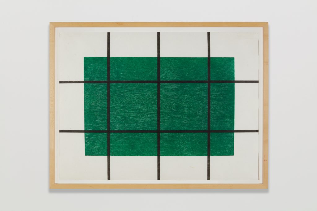 A photograph of a simple geometric print by Donald Judd featuring three columns and two rows of intersecting dark blue lines on a deep green rectangle and white background with a gold frame