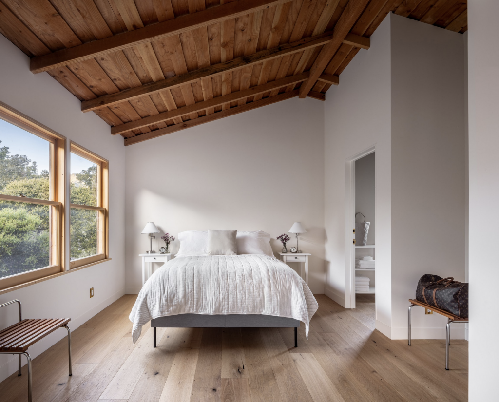 A photograph of the clean interior of a bedroom within a modern rennovated farmhouse