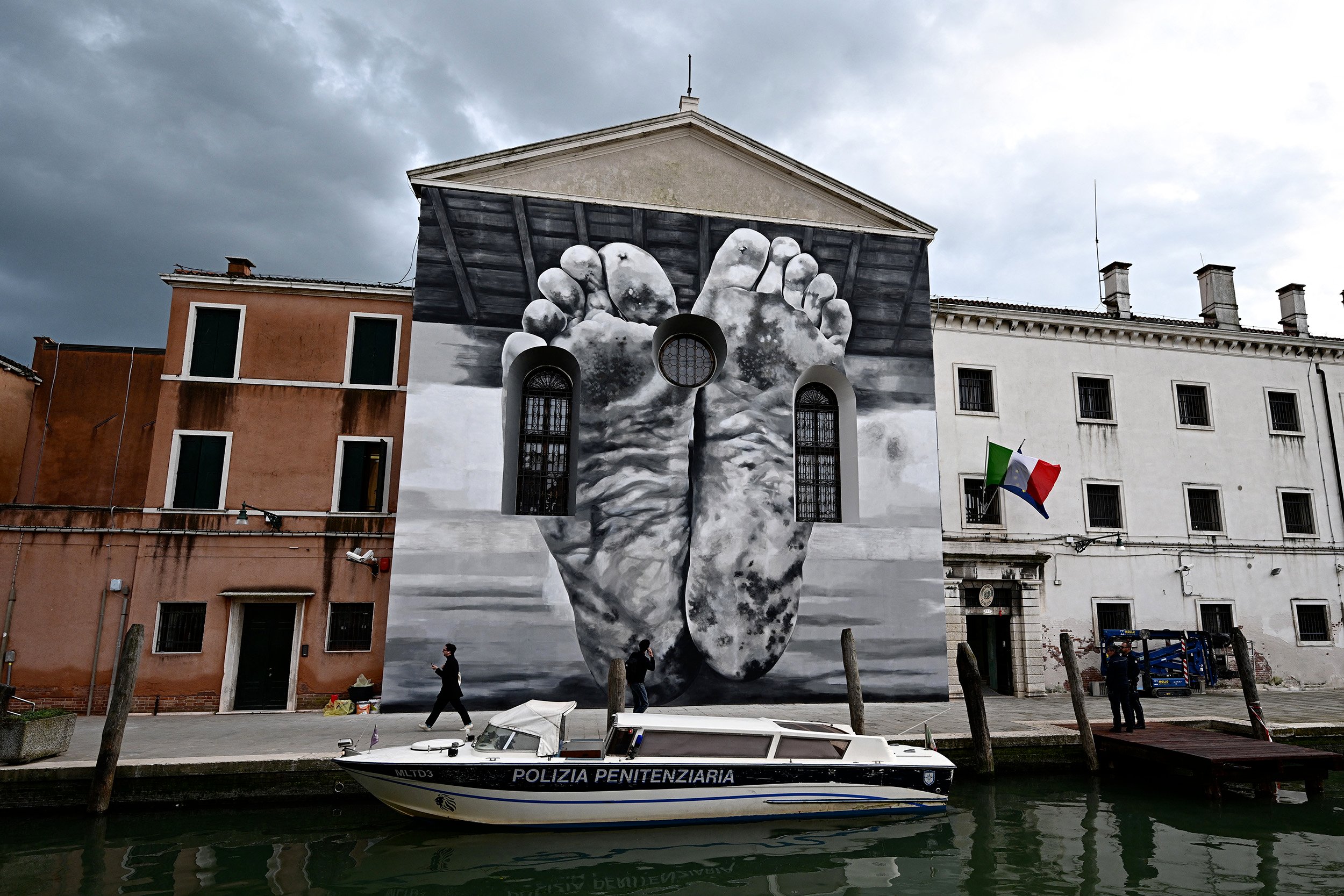 A mural depicting the soles of two dirty feet.