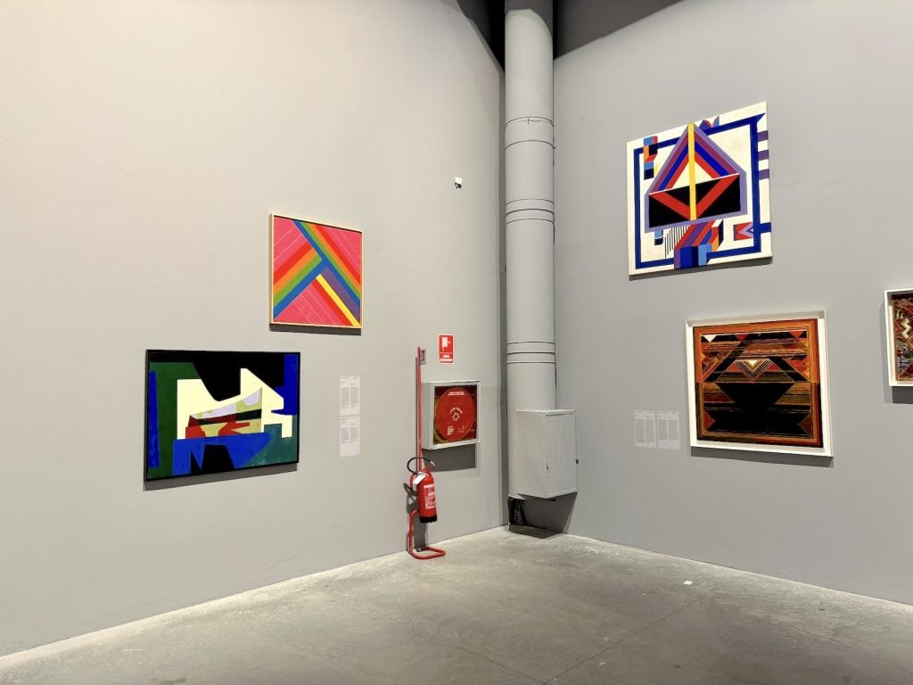 Four abstract paintings hung in a gallery