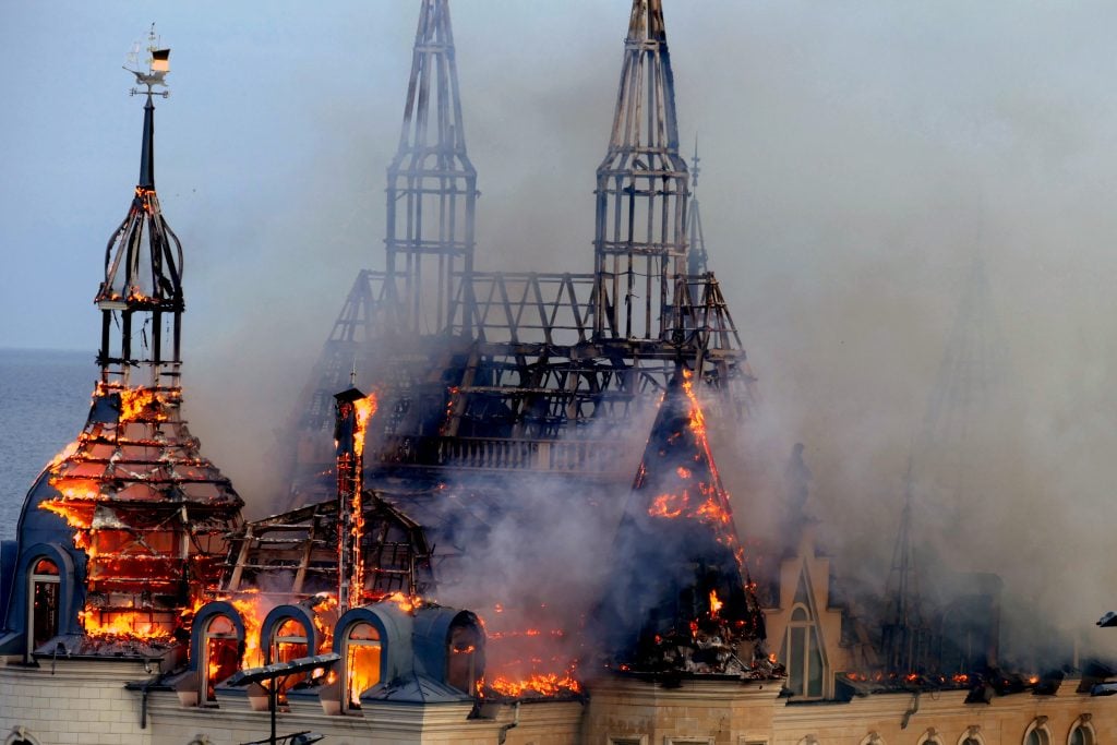 The spires of a Gothic style building on fire
