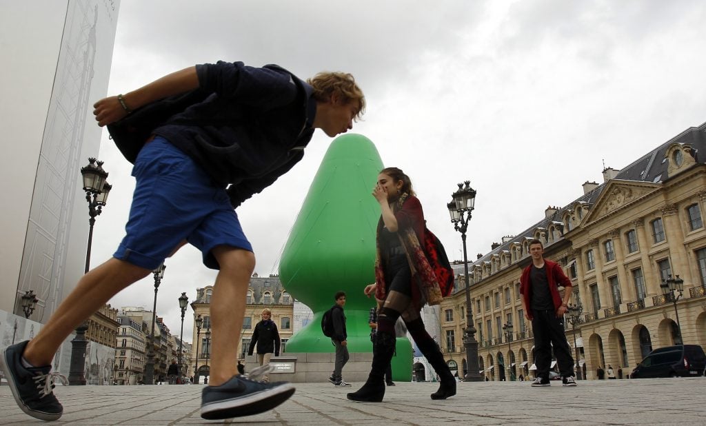 Parisians pose with Paul McCarthy's sculpture, which resembles a sex toy