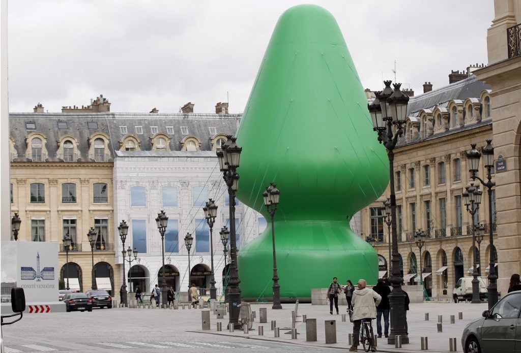 A large inflated butt plug sitting on a Parisian street