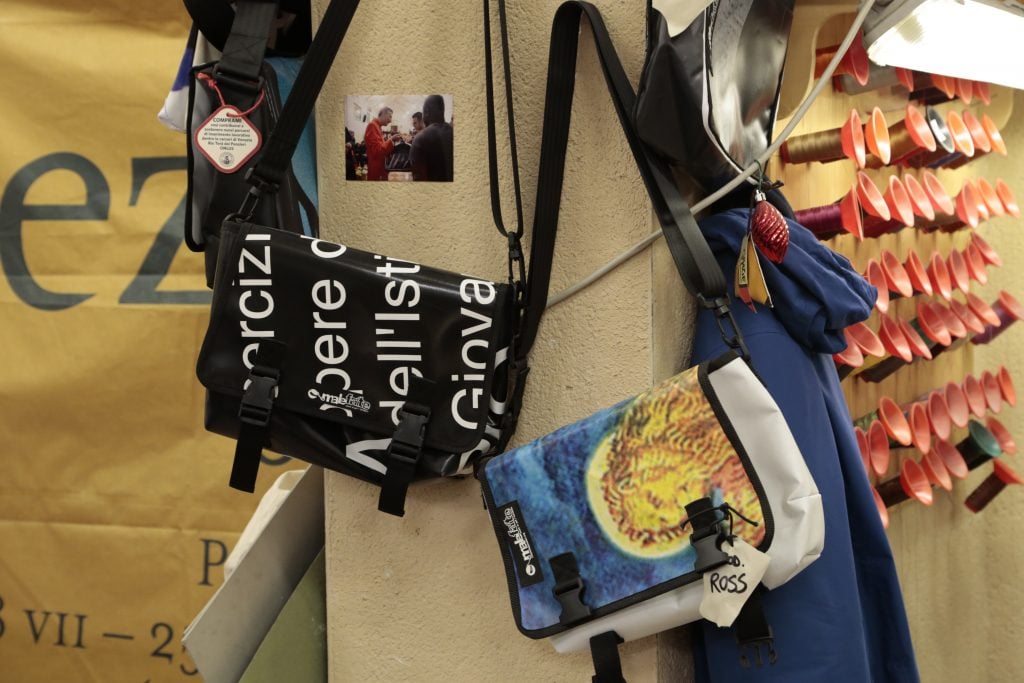 Bags made by the inmates of the men's prison in Venice are hung up for sale.