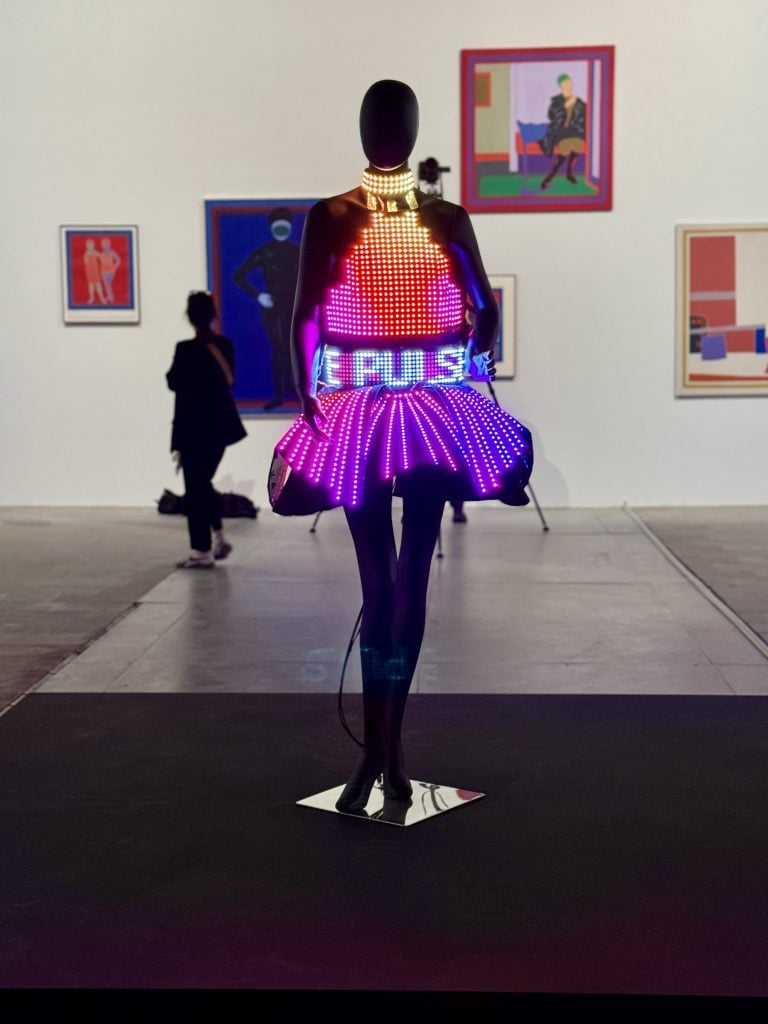 A mannequin wearing an electric dress with glowing pink lights and a belt that is flashing the word PULSE